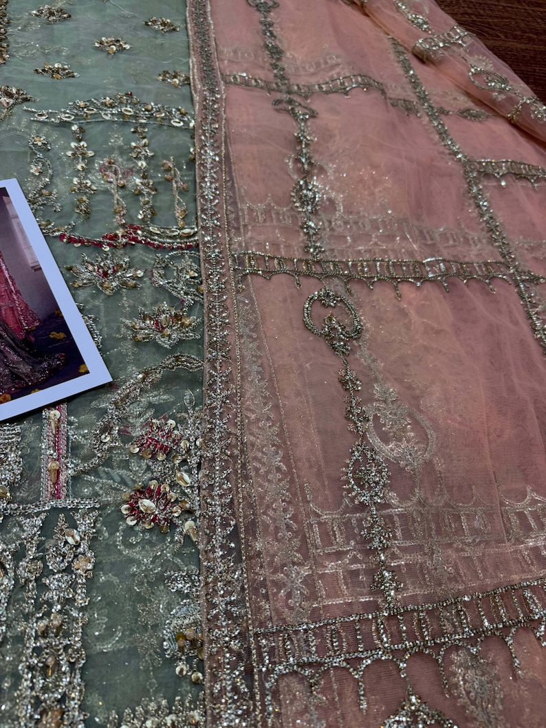 Peut inclure: Un tissu brod&eacute; vert clair et rose avec des embellissements argent&eacute;s. Le tissu pr&eacute;sente un motif floral d&eacute;licat et un design g&eacute;om&eacute;trique.