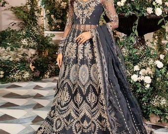 May include: A gray and gold embroidered dress with a sheer overlay and a matching dupatta. The dress features intricate floral and geometric patterns.