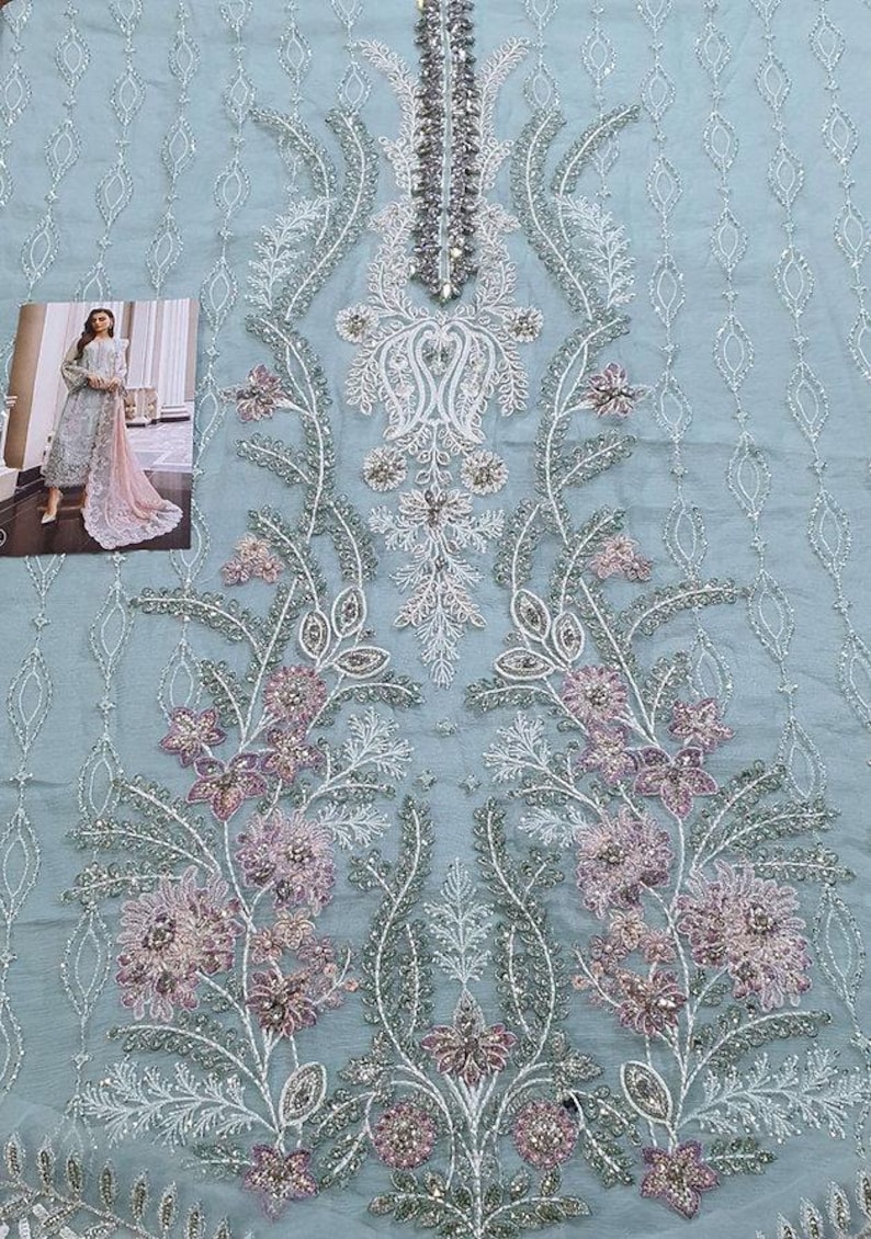 May include: A light blue fabric with intricate white and pink floral embroidery. The fabric is embellished with sequins and beads.