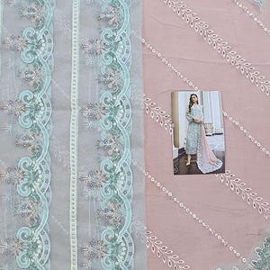 May include: A light blue and pink fabric with intricate floral embroidery. The fabric has a delicate, sheer texture and features a repeating pattern of leaves and flowers.