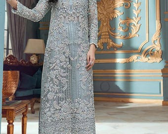 Puede incluir: Un vestido bordado azul claro con una superposición transparente y un cuello alto. El vestido tiene manga larga y un fondo de estilo pantalón corto. El vestido está decorado con adornos de perlas.