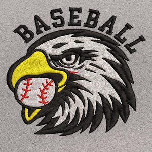 Puede incluir: Diseño bordado que presenta la cabeza de un águila con una pelota de béisbol en el pico. La palabra "BASEBALL" está arqueada sobre el águila. El águila tiene detalles amarillos, negros y blancos, y la pelota es blanca con costuras rojas.