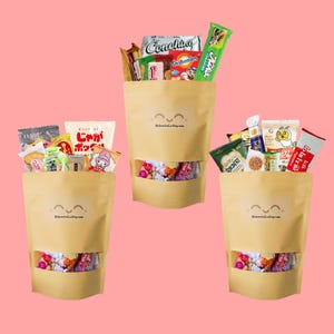 May include: Three light brown stand-up pouches filled with assorted snacks. Each pouch features a clear rectangular window at the bottom, a smiling face icon, and the text DLSnacksCo.Etsy.com. The bags are packed with various colourful snack packages.