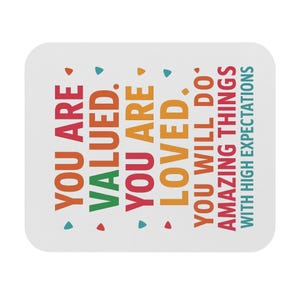 May include: A white, rectangular coaster with rounded corners. The coaster features colorful text that reads "YOU ARE VALUED. YOU ARE LOVED. YOU WILL DO AMAZING THINGS WITH HIGH EXPECTATIONS."