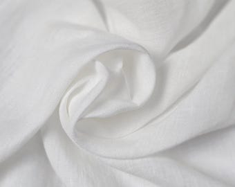 May include: White linen fabric with a smooth, soft texture. The fabric is folded and draped, showing its natural wrinkles and folds.