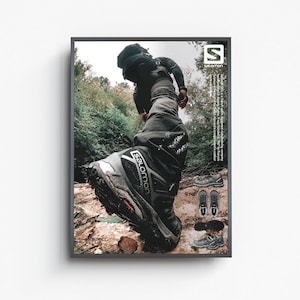 May include: A person wearing black hiking pants and a black jacket walks through a forest path. The person is wearing black hiking boots with the Salomon logo on the side. The image is a product advertisement for Salomon hiking boots.