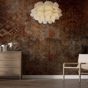 May include: A room with a textured, brown wall and a wooden floor. A white, layered pendant light hangs from the ceiling. Furnishings include a wooden dresser, a chair, and a small table. Decorative items are on the dresser and table.