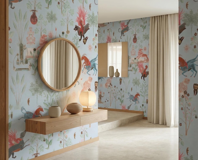 K&ouml;nnte beinhalten: Hellblaue Tapete mit einem skurrilen Design mit Fabelwesen, B&auml;umen und floralen Elementen. Ein runder Holzspiegel h&auml;ngt an der Wand &uuml;ber einer Holzkonsolentisch mit dekorativen Vasen und einer Lampe. Der Raum hat eine moderne, k&uuml;nstlerische &Auml;sthetik.