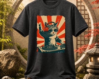 May include: A dark gray short-sleeve t-shirt featuring a graphic print of a cat wearing red headphones and sunglasses, positioned behind a DJ turntable. The background of the graphic consists of red and white sunburst rays in a retro style.