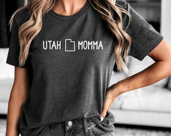 Może przedstawiać: Szary t-shirt z białym napisem "UTAH MOMMA" i białym obrysem stanu Utah.