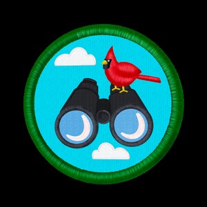 Puede incluir: Un parche bordado circular que presenta un pájaro cardenal rojo brillante posado sobre unos binoculares negros contra un fondo de cielo azul claro con nubes blancas, todo dentro de un borde grueso y texturizado en verde oscuro.