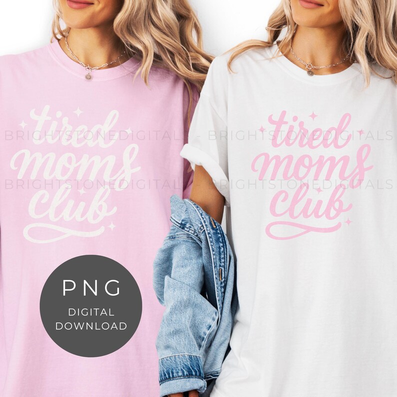 May include: Two t-shirts, one pink and one white, each with the text "tired moms club" in a cursive font. The pink shirt has a matching design, while the white shirt has a blue denim jacket draped over the arm.