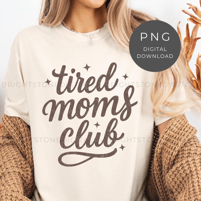 May include: Cream-colored t-shirt with the text "tired moms club" in a brown, cursive font. The design includes small star accents. A circular graphic in the upper right corner reads "PNG DIGITAL DOWNLOAD".