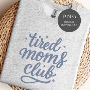 May include: Light gray sweatshirt with the text "tired moms club" in blue script. The sweatshirt has a crew neck and long sleeves. A digital download PNG graphic is in the upper right corner.