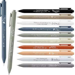 May include: A selection of pens in various colours, each inscribed with an inspirational quote and floral design. The pens are in shades of black, beige, white, blue, green, orange, and grey. Each pen has a different quote and floral illustration.