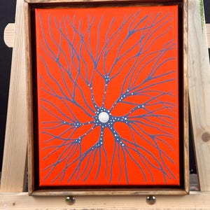May include: A framed painting of a stylized neuron with a white circle in the center and blue branches on an orange background.