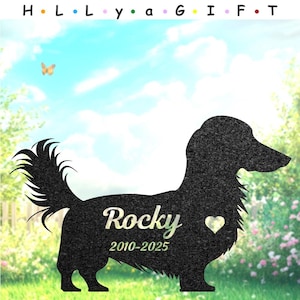 Puede incluir: Silueta de perro salchicha de metal negro con el nombre "Rocky" y las fechas 2010-2025, con un detalle de corazón. El fondo presenta un cielo azul, una mariposa y un jardín. El texto "H. L. L. y a G I F. T" está en la parte superior.