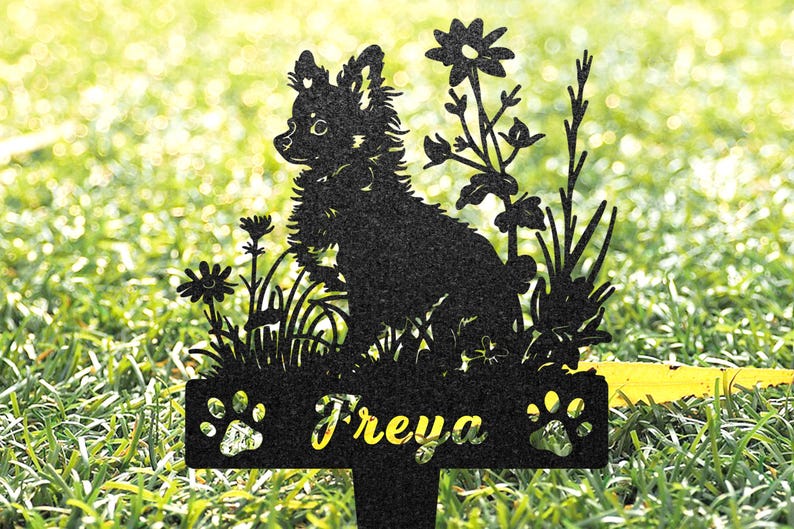 K&ouml;nnte beinhalten: Schwarze Metallsilhouette eines Chihuahua-Hundes mit Blumen und dem Namen "Freya" auf einer Plakette. Die Silhouette befindet sich auf einem gr&uuml;nen Gras Hintergrund.