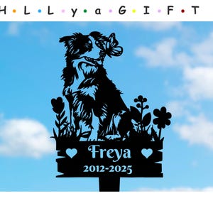 May include: Black silhouette of a border collie dog with a butterfly on its head, standing in a field of flowers. The dog is looking to the right. A sign below the dog reads "Freya 2012-2025".