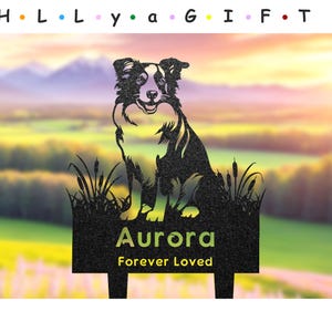 May include: Black metal silhouette of a border collie dog sitting in a field of tall grass. The dog is looking to the right. The metal silhouette is attached to a black metal stake with the words "Aurora Forever Loved" on a plaque.