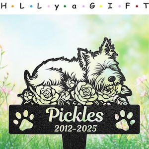 Könnte beinhalten: Schwarzer Garten-Gedenkstein aus Metall mit einer weißen Silhouette eines schlafenden Hundes in einem Rosenbeet. Das Schild trägt die Aufschrift "Pickles 2012-2025" mit Pfotenabdrücken auf beiden Seiten.