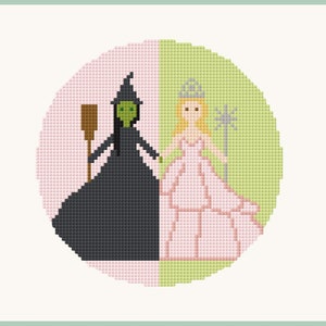 May include: A needlepoint design featuring the Wicked Witch of the West and Glinda the Good Witch. The design is circular and features a pink and green background.