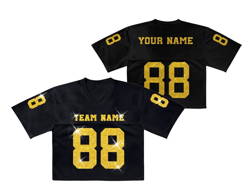 K&ouml;nnte beinhalten: Ein schwarzes kurz&auml;rmeliges Trikot mit goldfarbenen Glitzerbuchstaben und -zahlen. Auf der Vorderseite steht TEAM NAME &uuml;ber der Nummer 88, auf der R&uuml;ckseite YOUR NAME &uuml;ber der Nummer 88. Weitere 8er befinden sich auf den &Auml;rmeln.