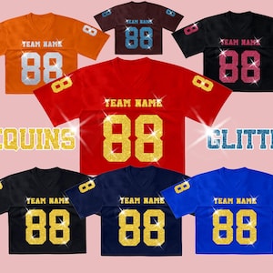 K&ouml;nnte beinhalten: Eine Sammlung von sieben kurz&auml;rmeligen V-Ausschnitt-Trikots in Orange, Braun, Schwarz, Rot, Marineblau und Blau. Jedes Trikot zeigt den Text TEAM NAME und die Nummer 88 in Glitzer- oder Paillettenoptik. Die W&ouml;rter SEQUINS und GLITTER sind als Text zu sehen.