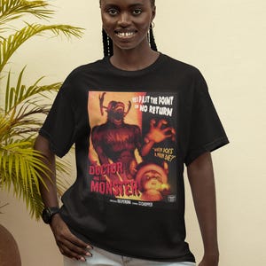 May include: Black t-shirt featuring a vintage-style movie poster with the text "THE DOCTOR AND THE MONSTER." The poster includes the phrases "HES PAST THE POINT OF NO RETURN" and "WHEN DOES A MAN DIE?" The design is in shades of red, orange, and brown.