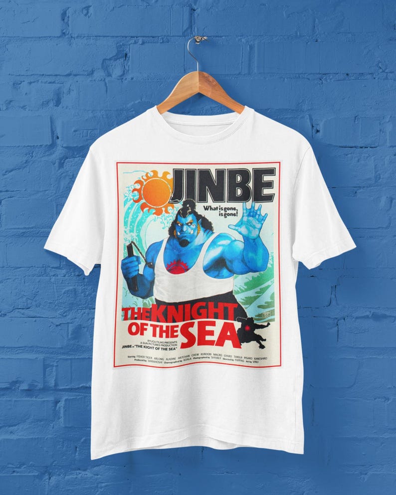 May include: White t-shirt featuring a graphic of a blue-skinned character with the text "JINBE" and "THE KNIGHT OF THE SEA." The design includes a sun and the phrase "What is gone, is gone!"