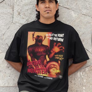 May include: Black t-shirt featuring a vintage movie poster design. The poster art includes a monster and the text "THE DOCTOR AND THE MONSTER", with the phrases "HE'S PAST THE POINT OF NO RETURN" and "WHEN DOES A MAN DIE?"