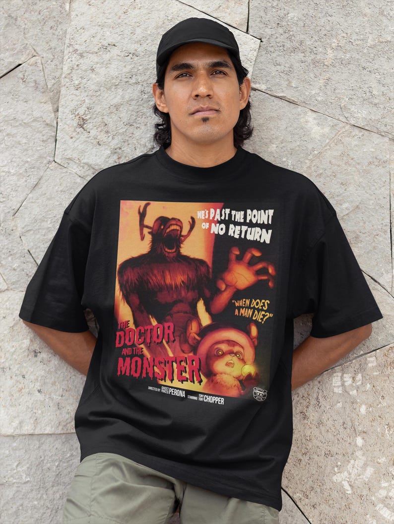 May include: Black t-shirt featuring a vintage movie poster design. The poster art includes a monster and the text "THE DOCTOR AND THE MONSTER", with the phrases "HE'S PAST THE POINT OF NO RETURN" and "WHEN DOES A MAN DIE?"