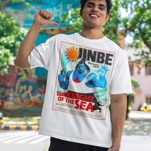 May include: White t-shirt featuring a graphic of a blue-skinned character with the text "JINBE" and "THE KNIGHT OF THE SEA." The design includes a sun, waves, and the phrase "What is gone, is gone!"