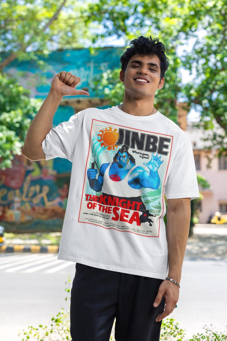 May include: White t-shirt featuring a graphic of a blue-skinned character with the text "JINBE" and "THE KNIGHT OF THE SEA." The design includes a sun, waves, and the phrase "What is gone, is gone!"