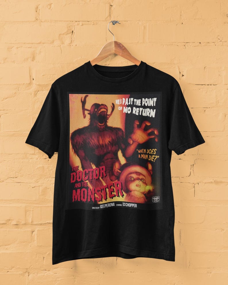 May include: Black t-shirt featuring a vintage-style graphic. The graphic includes a monster and a character with the text "THE DOCTOR AND THE MONSTER". Additional text reads "HE'S PAST THE POINT OF NO RETURN" and "WHEN DOES A MAN DIE?"