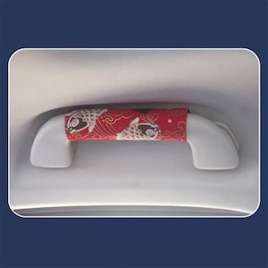 May include: Red and gold fabric car handle cover with a koi fish pattern.