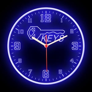 May include: A blue and white clock with a key design and the word "KEYS" on the face. The clock hands are red and white.