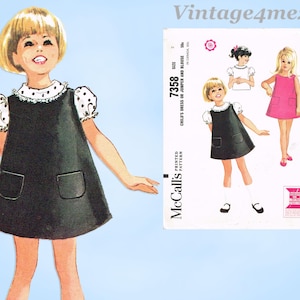 Könnte beinhalten: Vintage McCall's Schnittmuster für ein Kinderkleid oder einen Jumper und eine Bluse. Das Muster zeigt einen schwarzen Jumper mit weißen gepunkteten Ärmeln und einem weißen Kragen. Das Muster enthält auch Illustrationen des Kleides und der Bluse.