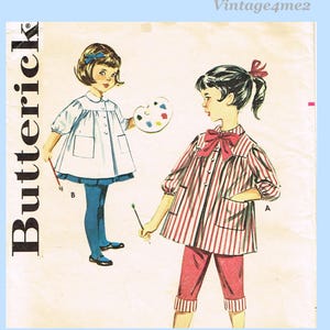 Può includere: Modello di cucito Butterick vintage con due ragazze in abiti a tema artista. Una ragazza indossa un vestito bianco con calzamaglia blu, con un pennello e una tavolozza. L'altra indossa una maglia a righe rosse e bianche e pantaloni capri rossi.