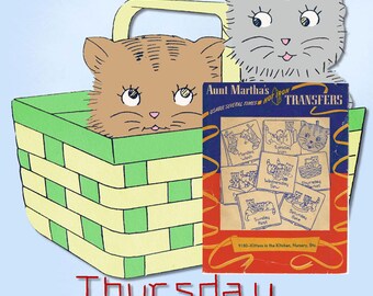 May include: A vintage illustration features two cartoon cat heads, one in a green and yellow basket. A booklet titled "Aunt Martha's Hot Iron Transfers" shows various kitten designs. The text "Thursday Market" is at the bottom.