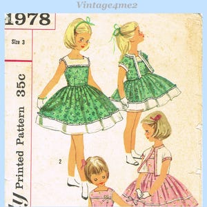 Könnte beinhalten: Vintage Schnittmuster mit Illustrationen von Mädchen in Kleidern. Die Kleider sind grün und rosa mit weißem Besatz. Das Muster ist mit "1978" und "Größe 3" gekennzeichnet. Der Text "Vintage4me2" steht oben.
