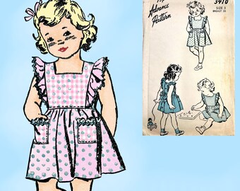 Op de afbeelding: Illustratie van een klein meisje in een roze polkadot en gingham schortjurk met ruches mouwen en zakken. De afbeelding bevat ook een vintage naaipatroon met jurkillustraties en de tekst "Advance Pattern".