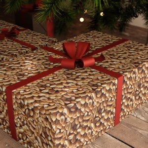 May include: Two gift boxes wrapped in brown paper with a peanut pattern and tied with red ribbon bows. The boxes are sitting on a wooden surface.