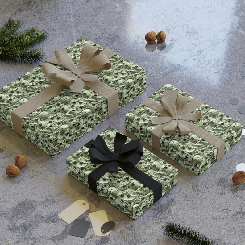Op de afbeelding: Drie cadeaudozen verpakt in groen en bruin papier met een schedelpatroon. De dozen zijn vastgebonden met bruin, zwart en beige lint.
