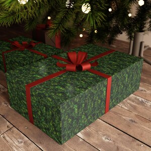May include: Two Christmas presents wrapped in green paper with a red ribbon and bow. The presents are sitting on a wooden floor under a Christmas tree.