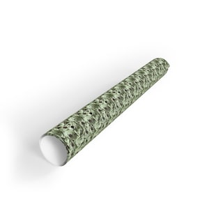 Op de afbeelding: Een rol cadeaupapier met een groen en bruin patroon.