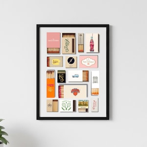 May include: A framed print featuring a collection of vintage matchboxes. The matchboxes are in various colors and designs, with text and graphics. The brands include "Alexander", "Albert's", "Lukes", "Capri", "Alo Yoga", and "Pizza".