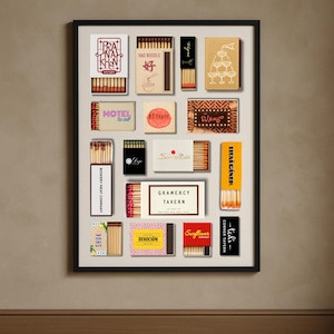 May include: A framed print featuring a collection of vintage matchboxes. The matchboxes display various designs and text, including "PRA NA KHEN", "HAO NOODLE", "MOTEL", "ATTALOT", "DJANGO", "BOWERY MEAT COMPANY", "SHUK", "GRAMERCY TAVERN", "THAI DINER", "DEVOCI&Oacute;N", and "Sunflower".