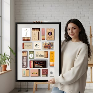 May include: A framed collection of vintage matchboxes, featuring various designs and logos. The matchboxes showcase a range of colors, including beige, red, and gold. Some boxes display text such as "GILLIGAN'S" and "RAINBOW ROOM OBSERVATION".