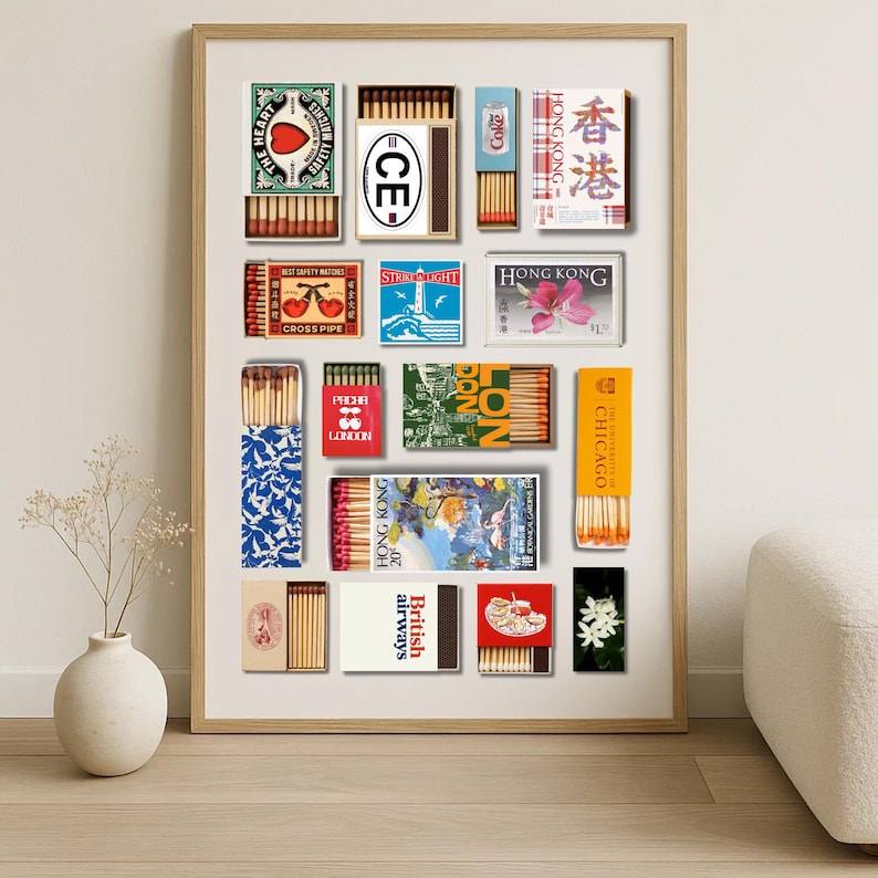 May include: A framed print featuring a collection of vintage matchboxes. The matchboxes display various designs, including text and graphics. Some boxes have text like "HONG KONG", "CHICAGO", and "British airways". The color palette includes red, blue, and yellow.